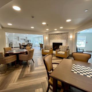 A cozy, modern living room with a fireplace, tables, and comfortable seating arrangements.
