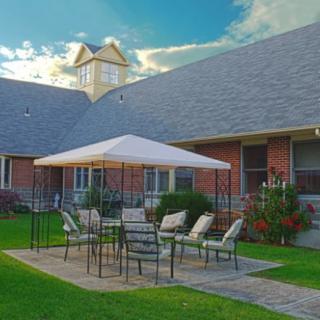 A cozy backyard patio with outdoor furniture under a gazebo.