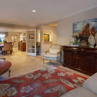 A well-decorated living room featuring comfortable seating, elegant furniture, and decorative artwork.