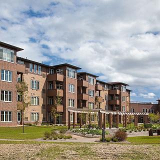 A view of a modern apartment building with landscaped gardens.