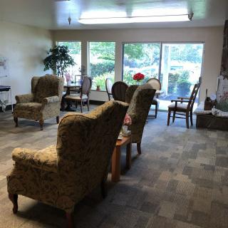 A cozy living room with several chairs and a large window offering a view of the outdoors.