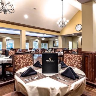 An elegant restaurant dining area with neatly set tables and chandeliers.