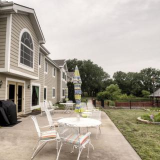 A spacious backyard featuring a patio with outdoor furniture and a well-maintained lawn.
