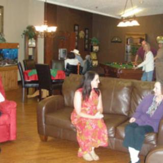 A group of people engaging in conversation in a cozy living room setting.