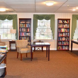 A cozy reading room featuring bookshelves, comfortable seating, and plenty of natural light.