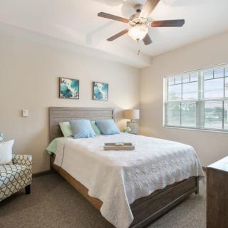 A cozy bedroom with a double bed, ceiling fan, and natural light coming through the window.
