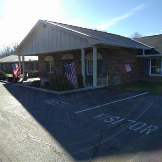 A sunny view of a residential building with flags displayed outside.