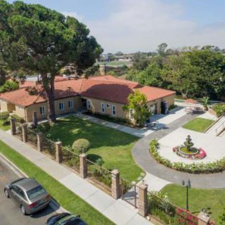 Aerial view of a suburban house with a circular driveway and landscaped garden.