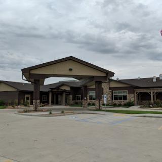 A welcoming entrance to a residential care facility under a cloudy sky.