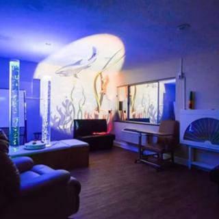 A modern living room with ambient lighting and a large aquarium.