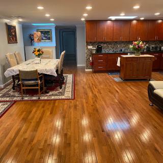 A spacious and modern living and dining area with elegant hardwood flooring and tasteful decor.