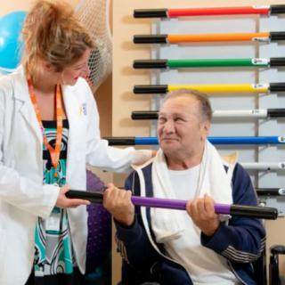 A therapist assists a patient during a physical therapy session.