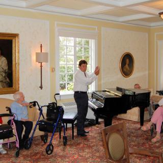 A lively piano performance entertaining an audience at a nursing home.