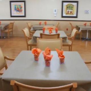 A neatly arranged dining area with tables, chairs, and colorful napkin decorations.