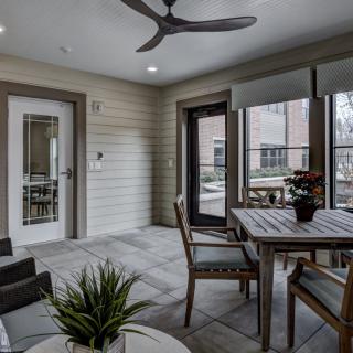 A cozy indoor patio featuring a dining set and decorative plants.