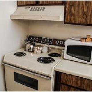 A retro-style kitchen with a stove, oven, and microwave.