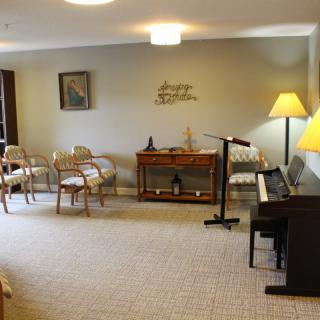 A cozy living room with a piano, seating area, and decorative elements.