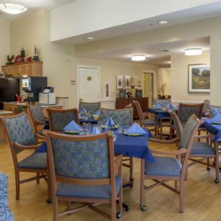 A cozy dining area with neatly arranged tables and chairs, set up for a meal.
