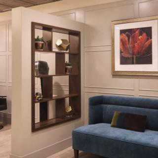 A modern interior space featuring a decorative shelf and a blue couch.