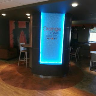 A modern interior view of a restaurant lobby featuring a glowing blue sign.