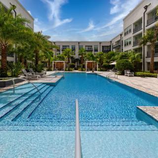 A luxurious outdoor pool area surrounded by palm trees, perfect for a relaxing vacation.