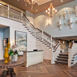 Elegant interior with a grand staircase and chandelier.