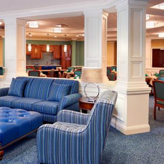 A modern and spacious lounge area with blue upholstered furniture and a comfortable seating arrangement.