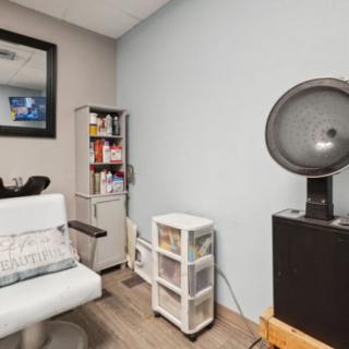 Cozy salon room with a hair dryer and books on shelves.