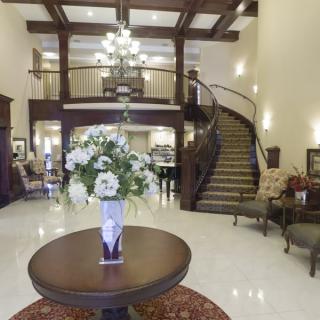Elegant lobby with a spiral staircase and floral centerpiece.