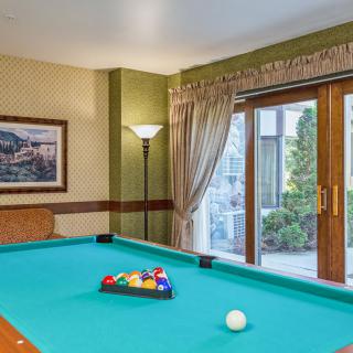 A cozy game room featuring a pool table ready for a match.