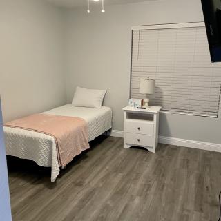 A minimalist bedroom with a single bed and neutral colors.