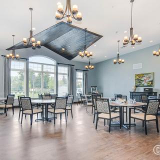 A spacious and modern dining area with elegant chandeliers and large windows offering natural light.