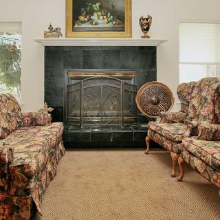 A traditional living room with floral furniture and a fireplace.