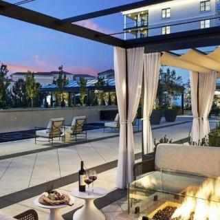 A luxurious outdoor patio with a fire pit, cozy seating, and wine for a relaxing evening ambiance.