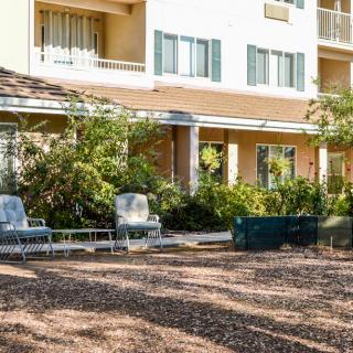 A well-maintained garden area with outdoor seating in front of a residential building.