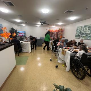 A lively gathering at a care facility, where residents enjoy a meal together.