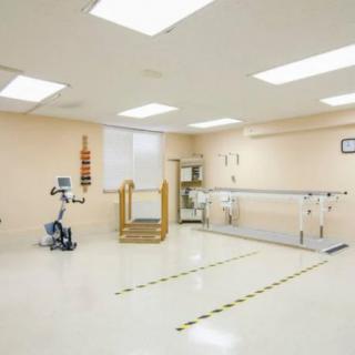 A clean and spacious physical therapy room equipped with exercise machines and rehabilitation tools.