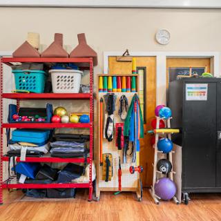 A well-organized area showcasing various exercise and therapy equipment on colorful shelves.