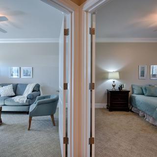 A split view of a living room and bedroom in a modern home.