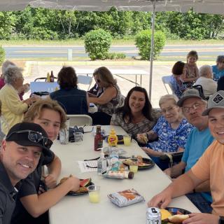A group of people enjoying a meal together at an outdoor gathering.