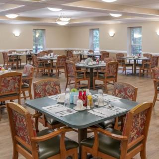 An empty dining room with neatly arranged tables and chairs.
