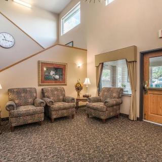 A cozy waiting area with patterned chairs, a clock on the wall, and soft lighting.
