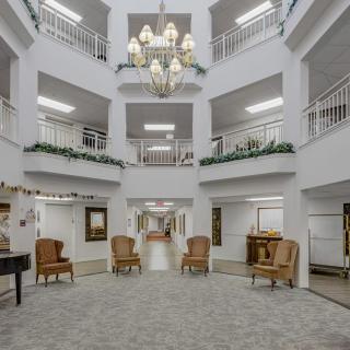 A multi-story atrium with a central chandelier, surrounded by balconies and seating areas.