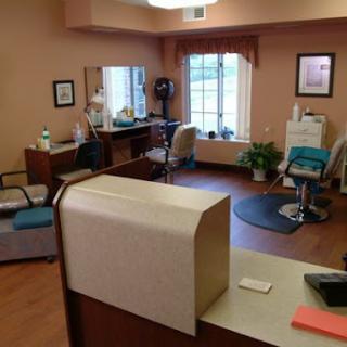 A cozy hair salon interior featuring a reception desk and styling stations.