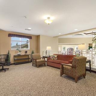 A cozy living room with sofas, chairs, and a carpeted floor.