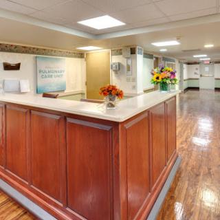 A welcoming reception area with a polished wooden counter and floral arrangements, designed to create a positive first impression.