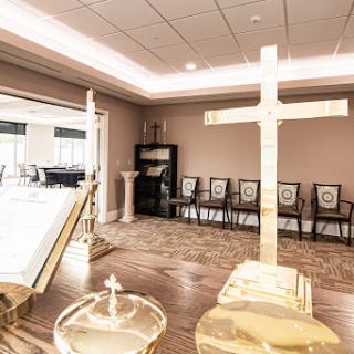 A serene chapel setting featuring a prominent cross and seating for reflection or ceremony.