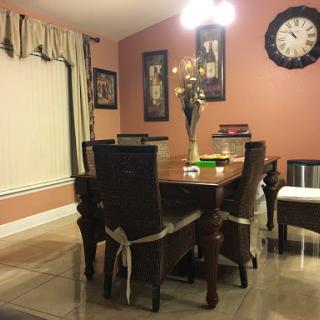 A cozy dining room featuring a wooden table surrounded by chairs, adorned with elegant wall decor and a warm color palette.