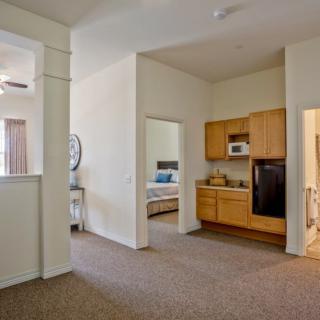A modern apartment with an open layout featuring a compact kitchen and adjacent bedrooms.
