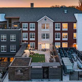A beautifully designed courtyard surrounded by contemporary buildings at sunset.